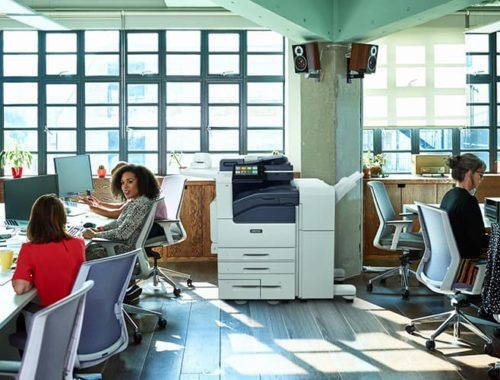 Squadra al lavoro in uno spazio aperto con la stampante monocromatica Xerox® VersaLink® B7100 Serie