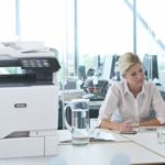 Due donne al lavoro in un ufficio accanto a una stampante multifunzione a colori Xerox® VersaLink® C625